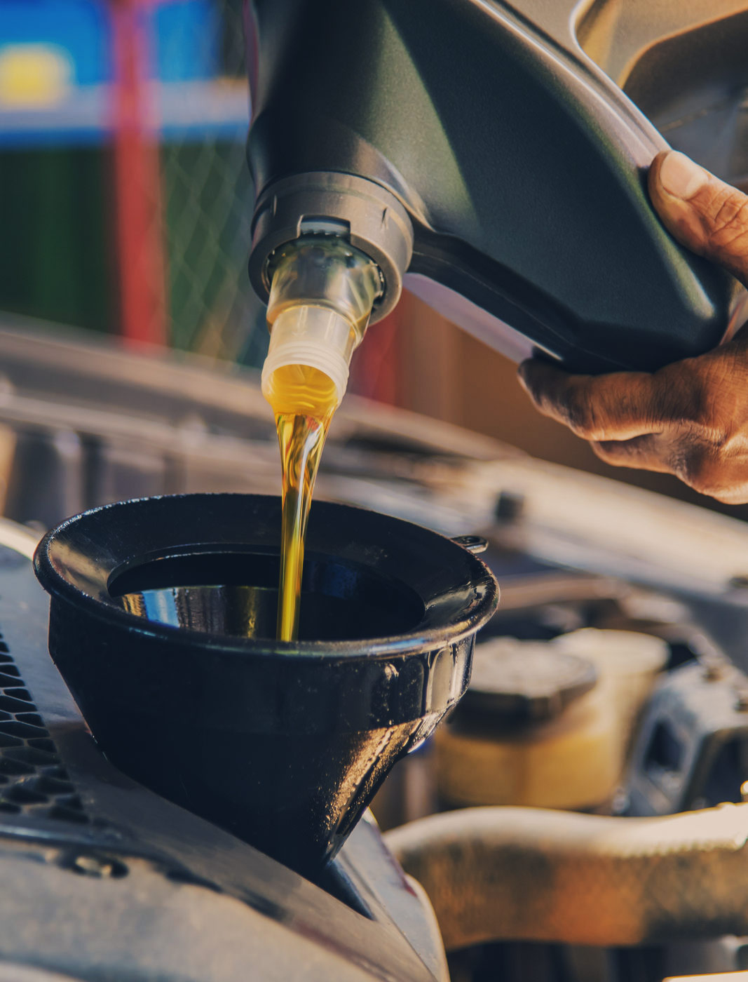 Mechanic pouring engine oil into a vehicle - Car Servicing Glenrothes, Fife