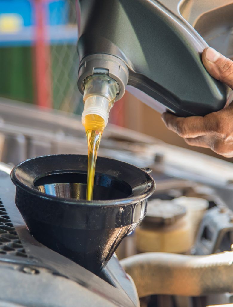 Mechanic pouring engine oil into a vehicle - Car Servicing Glenrothes, Fife